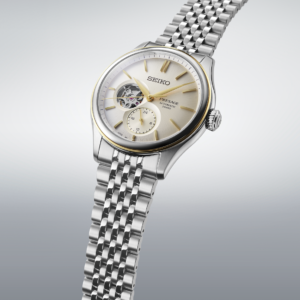 Seiko silver gold automatic watch with cream dial, gold-tone hands, open-heart display, and silver metal bracelet. Copy