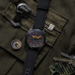 Seiko 5 Sports SRPH33 black dial automatic field watch with orange accents and black nylon strap. Copy Alt Text