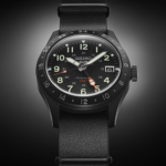 Seiko 5 Sports SSK025 black GMT automatic watch with red-orange GMT hand and black leather strap.